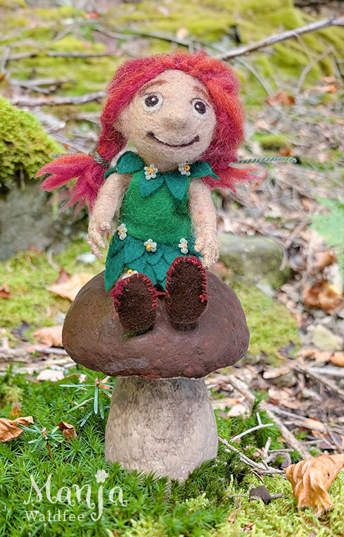 Manja sitzt auf einem Steinpilz